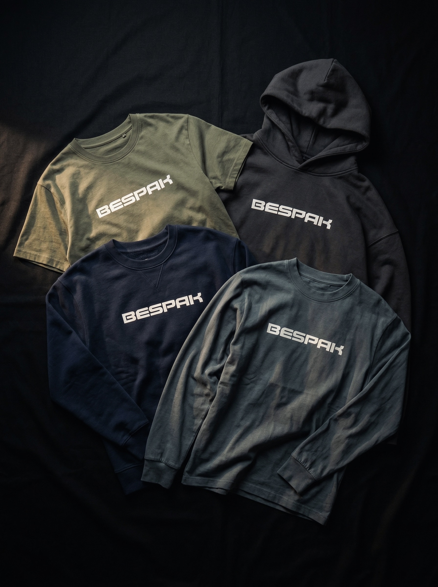 Bespak casual wear collection — hoodies and long sleeves laid flat on dark fabric